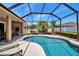 Enjoy the sun in this screened-in pool area featuring a large pool, well-manicured landscaping and an outdoor dining set at 4706 Josselin Pl, Parrish, FL 34219