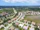 Stunning aerial view of the community with lush landscaping, homes, lake, and ocean view in the distance at 5106 Far Oak Cir, Sarasota, FL 34238