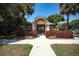 Charming community center with tiled roof and pergola framed by red shrubs and meticulously maintained grounds at 5106 Far Oak Cir, Sarasota, FL 34238