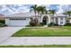A beautiful single-story home showcases a white tile roof, arched windows, and lush landscaping at 5106 Far Oak Cir, Sarasota, FL 34238