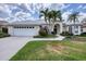 The exterior of this home features a well-manicured lawn, beautiful landscaping, and a two-car garage at 5106 Far Oak Cir, Sarasota, FL 34238