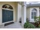 The grand front door has a arched transom window and sidelights plus manicured landscaping at 5106 Far Oak Cir, Sarasota, FL 34238
