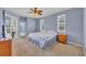 Main bedroom featuring a ceiling fan, bedside table, and natural light from the shuttered windows at 5106 Far Oak Cir, Sarasota, FL 34238