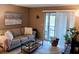 Comfortable living room featuring a plush sofa, glass coffee table, and sliding glass doors at 5400 26Th W St # F104, Bradenton, FL 34207