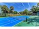 Vibrant blue and green community tennis court with fresh white lines and a clear net, set under a bright blue sky at 5400 26Th W St # F104, Bradenton, FL 34207