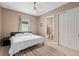Cozy bedroom featuring neutral walls, ceiling fan, and a comfy bed with a view to the bathroom at 5402 Tidewater Preserve Blvd, Bradenton, FL 34208