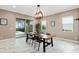 Dining area with a large table, contemporary light fixture, and view of outdoor pool at 5402 Tidewater Preserve Blvd, Bradenton, FL 34208