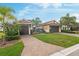 Charming single-Gathering home featuring a brick driveway and mature landscaping with palm trees at 5402 Tidewater Preserve Blvd, Bradenton, FL 34208