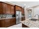 Elegant kitchen featuring dark wood cabinetry, granite countertops, and stainless steel appliances at 5402 Tidewater Preserve Blvd, Bradenton, FL 34208