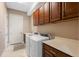 A tiled laundry room features a sink, a counter top, washer and dryer, and lots of cabinet space at 5402 Tidewater Preserve Blvd, Bradenton, FL 34208