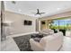 A living room features plush sofas, a modern ceiling fan and a view of the pool at 5402 Tidewater Preserve Blvd, Bradenton, FL 34208
