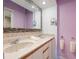 Bathroom features a double sink vanity with decorative backsplash and lavender walls at 5736 Ashton Lake Dr, Sarasota, FL 34231