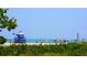 Picturesque beach scene with a lifeguard tower, beachgoers, and sailboats on the horizon at 5736 Ashton Lake Dr, Sarasota, FL 34231