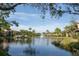 Exterior view of the building overlooking a pond with fountain under a blue sky with palm trees at 5736 Ashton Lake Dr, Sarasota, FL 34231