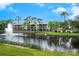 Exterior view of the building overlooking a pond with fountain under a blue sky with palm trees at 5736 Ashton Lake Dr, Sarasota, FL 34231