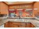 Kitchen sink with wooden cabinets and granite countertops at 5736 Ashton Lake Dr, Sarasota, FL 34231