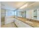 Bright bathroom featuring double sinks, granite countertops, tub, and walk-in shower at 6125 35Th E Ct, Bradenton, FL 34203