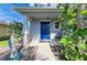 Inviting front porch with a bright blue door and decorative fish statue at 6125 35Th E Ct, Bradenton, FL 34203