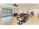 Open-concept living room with tile flooring, ceiling fan and sliding glass doors to a screened lanai at 6125 35Th E Ct, Bradenton, FL 34203