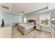 Spacious main bedroom featuring a tray ceiling, modern furniture, and light wood-style flooring at 6125 35Th E Ct, Bradenton, FL 34203