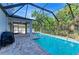 Lush screened-in pool with spacious patio, grill, and seating area for outdoor enjoyment and entertaining at 6125 35Th E Ct, Bradenton, FL 34203