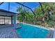 Relaxing screened-in pool area, surrounded by lush tropical landscaping, offering a private and serene backyard oasis at 6125 35Th E Ct, Bradenton, FL 34203
