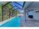 Screened-in pool with a stone paver deck and lush landscaping, perfect for outdoor relaxation and entertainment at 6125 35Th E Ct, Bradenton, FL 34203
