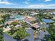 Aerial view of a community with a pool, tennis courts, clubhouse, palm trees, landscaping, and parking at 672 White Pine Tree Rd # 57, Venice, FL 34285