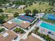 Aerial view showcasing shuffleboard and pickleball courts, a swimming pool, and tennis courts in a landscaped community at 672 White Pine Tree Rd # 57, Venice, FL 34285