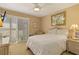 Comfortable bedroom featuring a ceiling fan, neutral walls, and a sliding glass door at 672 White Pine Tree Rd # 57, Venice, FL 34285
