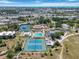Aerial showcasing tennis courts, pools, and clubhouse with the city skyline in the background at 672 White Pine Tree Rd # 57, Venice, FL 34285