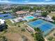 Aerial view showcasing various community amenities including tennis, shuffleboard, and swimming pool areas at 672 White Pine Tree Rd # 57, Venice, FL 34285