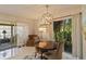 Bright dining room with modern light fixture, elegant furniture, and sliding doors to the outdoor area at 672 White Pine Tree Rd # 57, Venice, FL 34285