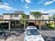 Exterior view of condo featuring covered parking and well-maintained landscaping at 672 White Pine Tree Rd # 57, Venice, FL 34285