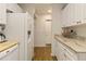 Bright kitchen featuring a white refrigerator, marbled countertops, and ample storage cabinets at 672 White Pine Tree Rd # 57, Venice, FL 34285