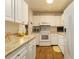 Bright kitchen featuring white appliances, marbled countertops, and ample storage cabinets at 672 White Pine Tree Rd # 57, Venice, FL 34285