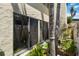Private courtyard featuring a row of sliding glass doors and lush tropical landscaping at 672 White Pine Tree Rd # 57, Venice, FL 34285