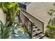 A view of the outdoor staircase leading to the upper level with mature foliage at 672 White Pine Tree Rd # 57, Venice, FL 34285