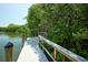 Wooden dock on calm water surrounded by lush greenery for scenic enjoyment at 6720 Northampton Pl, Bradenton, FL 34207