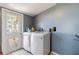 Bright laundry area with tiled flooring, modern appliances, and convenient access to an outdoor door at 6720 Northampton Pl, Bradenton, FL 34207