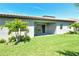 View of the backyard featuring a covered patio, manicured lawn, and partial landscaping at 6800 Dunlin Ct, Sarasota, FL 34241