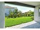 Inviting backyard showcasing green grass and lush tropical plants all protected by an elegant black metal fence at 6800 Dunlin Ct, Sarasota, FL 34241