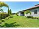 Well-maintained backyard featuring lush green grass, landscaping, and a secure black fence for privacy at 6800 Dunlin Ct, Sarasota, FL 34241