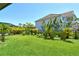 Expansive backyard with lush grass, tropical flora, and a sleek black fence, perfect for private outdoor living at 6800 Dunlin Ct, Sarasota, FL 34241