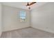 Bright bedroom with neutral carpet, ceiling fan and a window offering a view at 6800 Dunlin Ct, Sarasota, FL 34241
