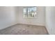 A quaint bedroom features neutral carpet and a sunny window overlooking palm trees at 6800 Dunlin Ct, Sarasota, FL 34241