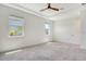 Bright, spacious bedroom with neutral carpet, tray ceiling, and natural light from dual windows at 6800 Dunlin Ct, Sarasota, FL 34241