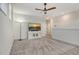 Bright bonus room with neutral carpet, ceiling fan and mounted television on cabinet at 6800 Dunlin Ct, Sarasota, FL 34241