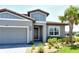 Charming home exterior boasting a lush green lawn, palm trees, and a three-car garage for ample parking space at 6800 Dunlin Ct, Sarasota, FL 34241