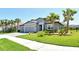 Inviting home with a neatly kept lawn, three-car garage, and swaying palm trees that enhance its curb appeal at 6800 Dunlin Ct, Sarasota, FL 34241